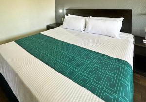 奥夫雷贡城InHouse Obregón的一张位于酒店客房的床铺,配有绿色和白色的毯子