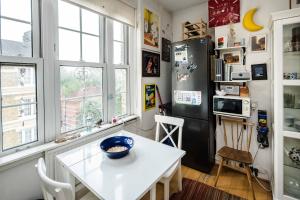 伦敦Stylish Central London Flat Near Tower Bridge的厨房配有白色的桌子和冰箱。