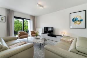 克诺克－海斯特Zonnig Luxueuze Appartementen La Coronne的客厅配有两张沙发和一台电视机