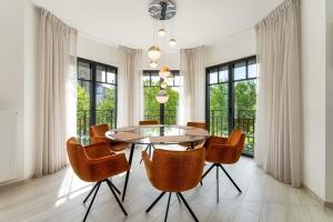 克诺克－海斯特Zonnig Luxueuze Appartementen La Coronne的一间设有玻璃桌和椅子的用餐室
