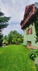 杜什尼基-兹德鲁伊Chata Zieleniecka的一座带长椅和桌子的绿色庭院