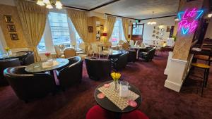 大雅茅斯NELSON Hotel的一间带桌椅的餐厅和一间酒吧