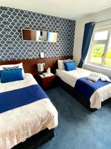 库申多尔库伦特拉别墅酒店的一间卧室设有两张床,墙上设有一面镜子