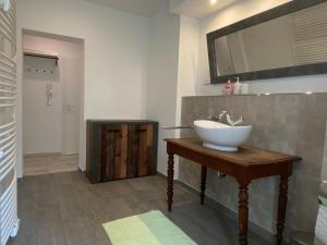 萨尔布吕肯Fischbach Apartment的木桌上带水槽的浴室