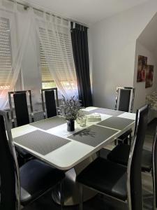 沃尔芬比特尔Wolfenbüttler Apartment的一间配备有白色桌椅的用餐室