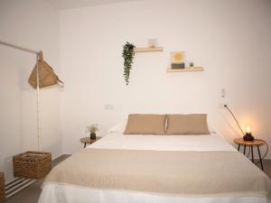 奇克拉纳－德拉弗龙特拉Villa Alegría的一间白色卧室,配有一张床和两张桌子