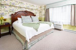 纽波特纽波特美洲帆船旅馆的一间卧室配有一张带花卉壁纸的大床