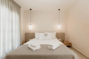 阿莫利亚尼岛TRINITY THE HOTEL的卧室配有白色床和毛巾
