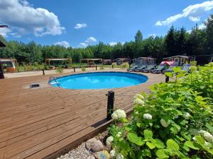 鲁恰内尼达NA KOŃCU WSI的一个带庭院的木甲板上的游泳池