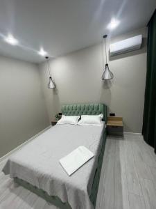 阿克托比Люксовая Квартира的一间卧室配有一张大床和两盏灯