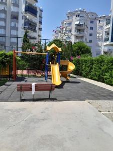 安塔利亚Denize Yakın Daire的一个带滑梯和长凳的游乐场的公园
