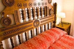 桑提亚纳德玛Hospedaje Octavio的一张带红色枕头的木制床头板的床