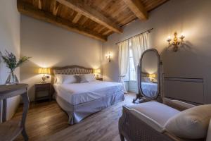 蒙福特达尔巴Tenuta Bussia - Wine Relais & Spa的一间卧室配有两张床、镜子和一张沙发