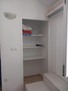 诺瓦利娅Studio Apartment Bosko的配有白色墙壁和架子的步入式衣柜