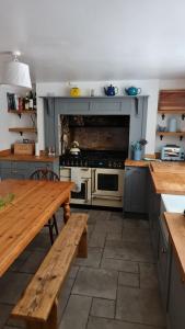 韦茅斯Blue Ensign Cottage的厨房配有炉灶和木桌。