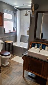 韦茅斯Blue Ensign Cottage的浴室配有盥洗盆、卫生间和浴缸。