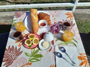 普纳奥亚Bungalow Miwa的一张早餐桌,早餐桌上有一盘食物放在毯子上