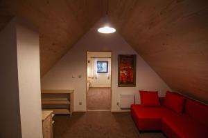 新塔尔格Domek w górach SmoLenisko的阁楼内的客厅配有红色沙发