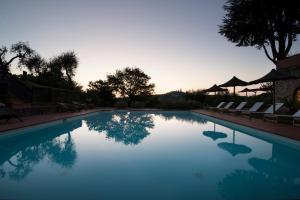 圣吉米纳诺Agriturismo I Pini的一个带椅子的游泳池,享有日落美景