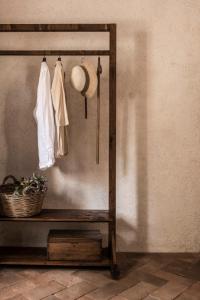 圣吉米纳诺Agriturismo I Pini的一间设有挂帽子和衣服的架子的房间