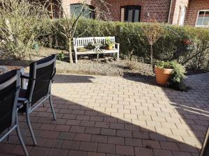 萨尔贝克FeWo Holunderbusch的庭院设有长凳和桌椅。