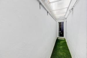 圣阿德里安-德贝索斯Barcelona Beach Vibes的一条带白色墙壁和绿色草地的走廊