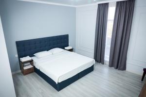 奇姆肯特Hotel Borjomi的一间卧室设有一张大床和一个窗户。