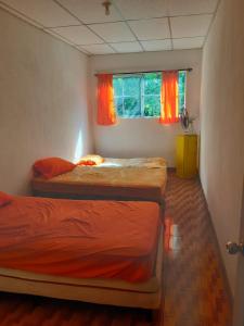 EscuintlaChalet El Paraiso的带窗户的客房内设有两张单人床。