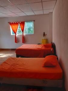 EscuintlaChalet El Paraiso的一间卧室设有两张床和窗户。
