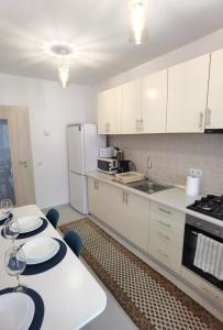 锡比乌Select Apartment SIBIU的厨房配有白色橱柜和白色台面
