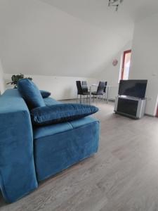 Spodnje GorjeApartma Julia的客厅设有蓝色沙发,配有电视