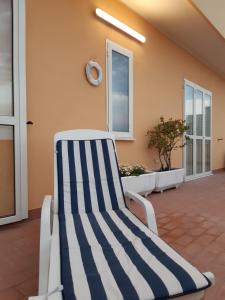 蒙特西尔瓦诺La Terrazza sul Mare的天井上的蓝白条纹椅子