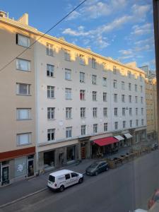 赫尔辛基Wonder studio apartment prime location and commute in the heart of Kallio的停在大楼前的白色货车