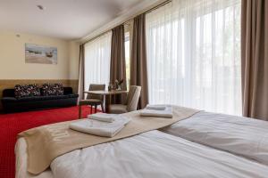 索波特KIWI Sopot Apartments的酒店客房带一张大床,带毛巾
