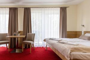 索波特KIWI Sopot Apartments的酒店客房带一张床、一张桌子和椅子
