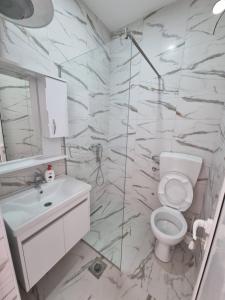 乌尔齐尼Kahari Apartments的白色的浴室设有卫生间和水槽。