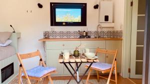 Staple CrossApple Orchard Shepherd Huts的一个带桌子和两把椅子的小厨房