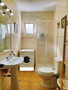 贝纳卢普-卡萨斯维耶哈斯El Capricho的浴室配有盥洗池、卫生间和洗衣机。