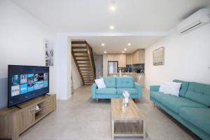巴特曼斯贝OHANA - SeaHome的客厅配有2张蓝色沙发和电视