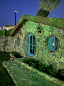 安塔利亚Maison Green Hill的一座由石头建筑制成的建筑,设有蓝色的窗户