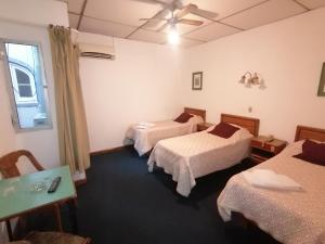 蒙得维的亚里士满酒店的酒店客房设有三张床和吊扇。