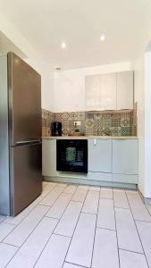 GouchaupréGîte les Tilleuls的厨房配有不锈钢冰箱和白色橱柜