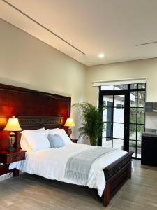 瓜塔佩1714 Hotel Boutique Guatapé的一间卧室配有一张大床和木制床头板