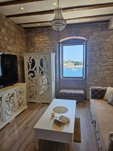 维斯Luxury Seafront Suite Fabri的带沙发、桌子和窗户的客厅