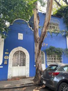 墨西哥城Villita San Gregorio的蓝色的房子,前面有停车位