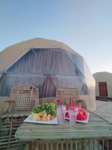 瓦迪拉姆Warm bubbles Wadi Rum的一张桌子,上面放着两盘食物和饮料