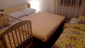戈斯皮奇Kuća za odmor Antonio的一间卧室配有两张床和一张婴儿床。
