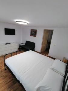 科尔贝尼Casa M.A.R.A的卧室配有一张白色大床和一把椅子