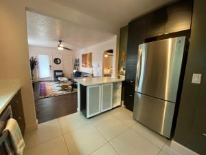 瓦拉瓦拉The Wesley Walla Walla的一间带不锈钢冰箱的厨房和一间客厅