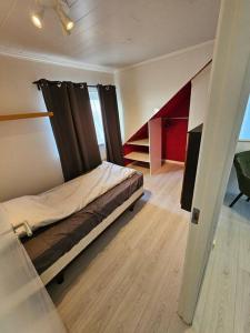 GardurVOT Vacation Homes-Akurhús的一间带床的卧室,位于带楼梯的房间